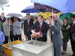 Herr Prof. Dr. Pfeiffer und Herr Heitmann versenken die Hülse bei der Grundsteinlegung am 23.05.2002